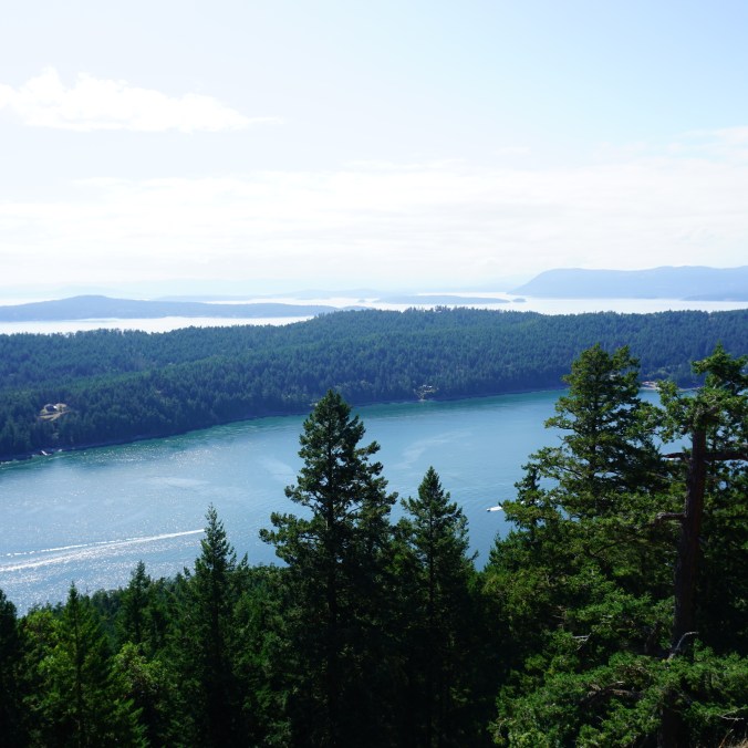 The view from the top of Mount Norman on Pender Island, BC, with the mountains and Pacific ocean in the background.