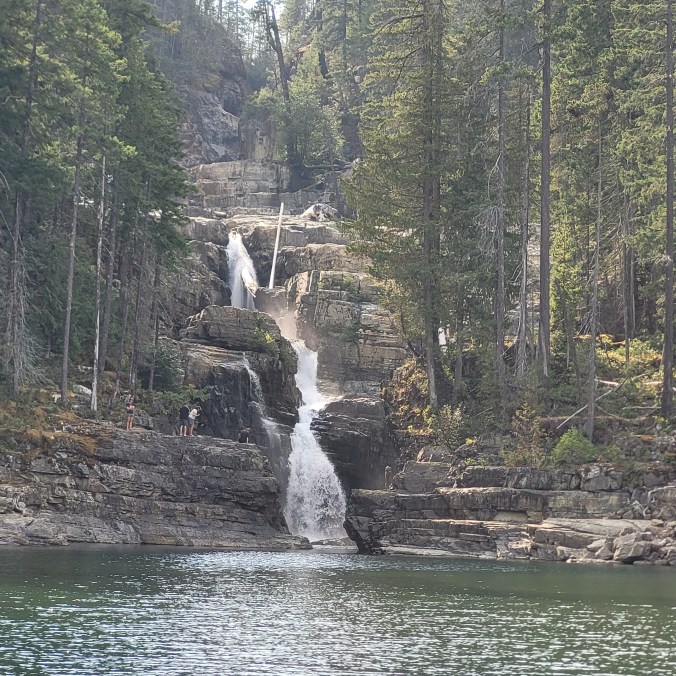 Little Myra Falls cascades over bare rock and into Buttle Lake on a sunny day in Strathcona Provincial Park on Vancouver Island, British Columbia, Canada.