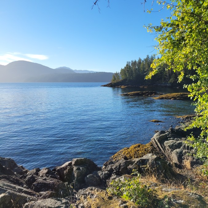 Sunny view of the ocean and beach at Fairview Bay on the Sunshine Coast Trail in British Columbia, Canada