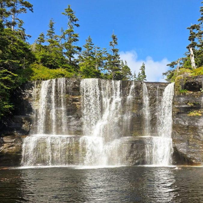 A beautiful sunny, blue sky day at Tsusiat Falls waterfall on the West Coast Trail on Vancouver Island, BC.